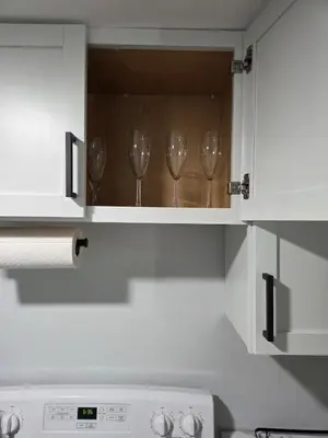 a kitchen with three wine glasses in a cabinet at Private Executive Suite in Waterbury