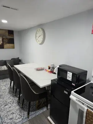 a kitchen with a table and a clock on the wall at Private Executive Suite in Waterbury