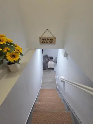 a hallway with a stairway with a couch and flowers at Private Executive Suite in Waterbury