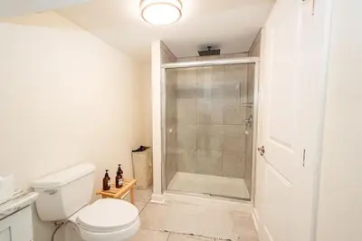 a bathroom with a toilet and a glass shower at Luxurious 4BD APT EV Parking in North Bergen