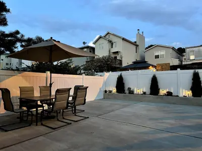 a patio with a table and chairs and an umbrella at Luxurious 4BD APT EV Parking in North Bergen
