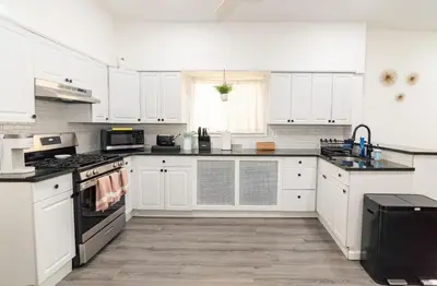 a kitchen with white cabinets and black appliances at Luxury North Bergen 3 BR APT in North Bergen
