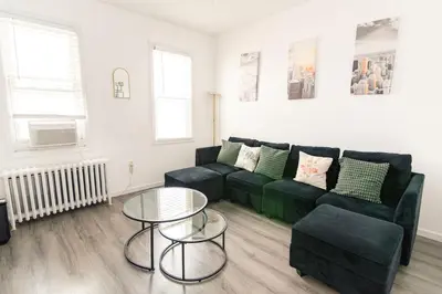 a living room with a black couch and a table at Luxury North Bergen 3 BR APT in North Bergen