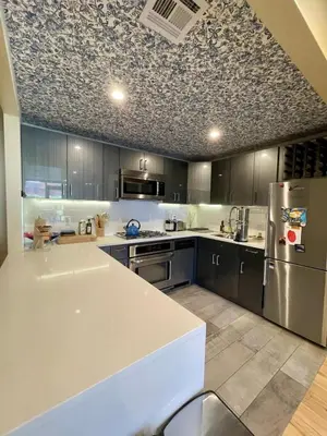 a kitchen with a white counter and a refrigerator at Bright 2-Story Brooklyn Oasis w Patio & Fire Pit in Brooklyn