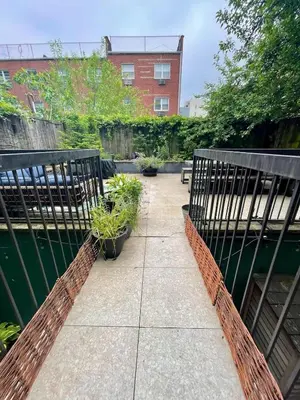 a garden with potted plants on a sidewalk at Bright 2-Story Brooklyn Oasis w Patio & Fire Pit in Brooklyn