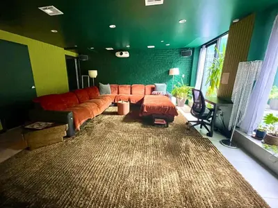 a living room with a orange couch and a large rug at Bright 2-Story Brooklyn Oasis w Patio & Fire Pit in Brooklyn