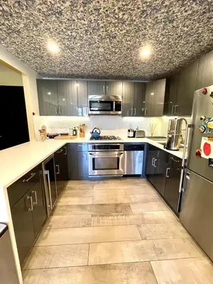 a kitchen with stainless steel appliances and a tile floor at Bright 2-Story Brooklyn Oasis w Patio & Fire Pit in Brooklyn