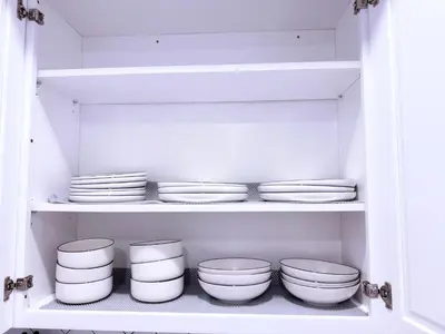 a kitchen with white bowls and plates on a shelf at Luxury Stay in Newark