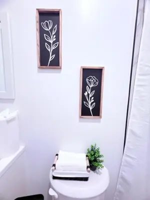 a bathroom with a toilet and three pictures on the wall at Luxury Stay in Newark