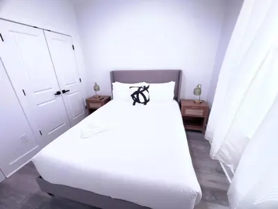 a bedroom with a white bed and two night stands at Luxury Stay in Newark