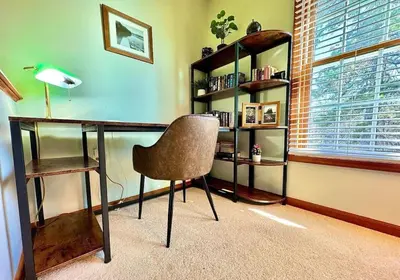 a desk with a chair in a room with a window at Charming Family Friendly House, Hot tub, Playroom in Long Pond
