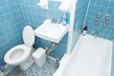a blue tiled bathroom with a toilet and a sink at Stylish2 Upper West Side Apartment 5-Min Walk to Central Park in New York