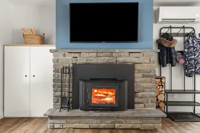a fireplace with a tv on top of it at Cozy Creekside Retreat - Minutes to Delhi & Andes in De Lancey