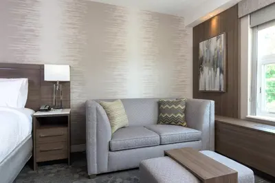 a hotel room with a couch and a bed at Courtyard by Marriott Edgewater NYC Area in Edgewater