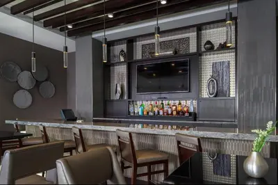 a restaurant with a bar with chairs and a tv at Courtyard by Marriott Edgewater NYC Area in Edgewater