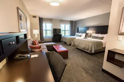 a hotel room with two beds and a living room at Staybridge Suites Albany Wolf Rd-Colonie Center by IHG in Albany