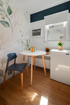 a small kitchen with a table and a chair at Birches Motel in Saratoga Springs