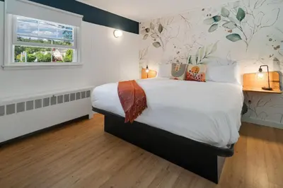 a bedroom with a large bed and a window at Birches Motel in Saratoga Springs