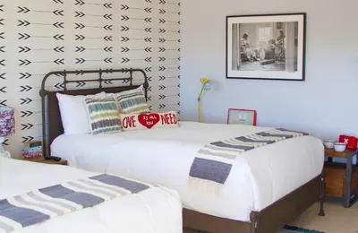 two twin beds in a room with a wall at Hotel Dylan in Woodstock