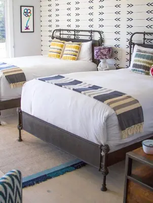 two beds in a bedroom with white walls at Hotel Dylan in Woodstock