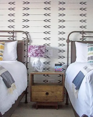 a bedroom with two beds and a night stand with a lamp at Hotel Dylan in Woodstock