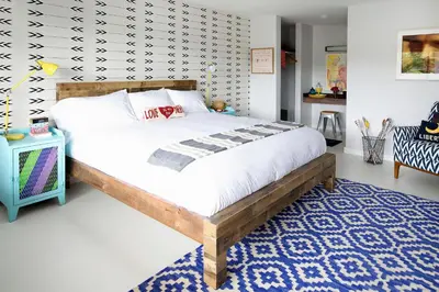 a bedroom with a large bed and a blue rug at Hotel Dylan in Woodstock