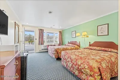 a hotel room with two beds and a television at Top Hill Motel in Saratoga Springs
