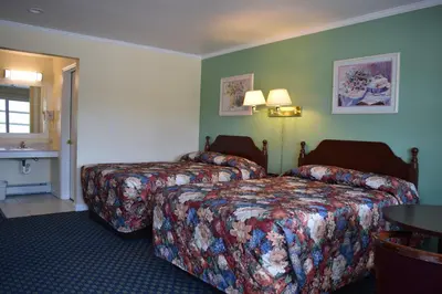a hotel room with two beds and a sink at Top Hill Motel in Saratoga Springs