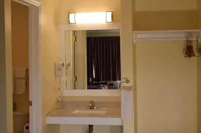 a bathroom with a sink and a mirror at Top Hill Motel in Saratoga Springs