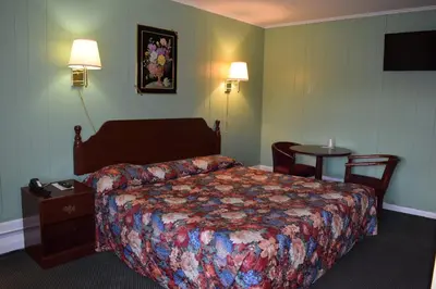 a hotel room with a bed and a table at Top Hill Motel in Saratoga Springs