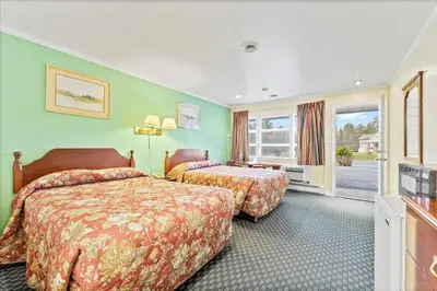 a hotel room with two beds and a television at Top Hill Motel in Saratoga Springs