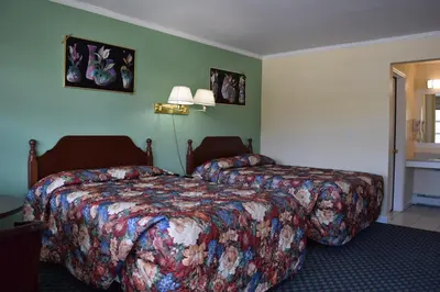 a hotel room with two beds and two lamps at Top Hill Motel in Saratoga Springs