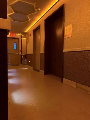 an empty hallway with doors and a tile floor at Umbrella Hotel Bronx in Bronx