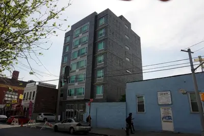 a tall building on the corner of a street at Umbrella Hotel Bronx in Bronx