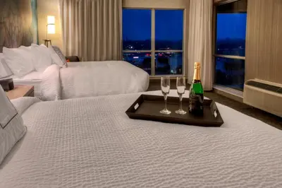 a hotel room with two glasses and a bottle of champagne at Courtyard by Marriott Westbury Long Island in Westbury