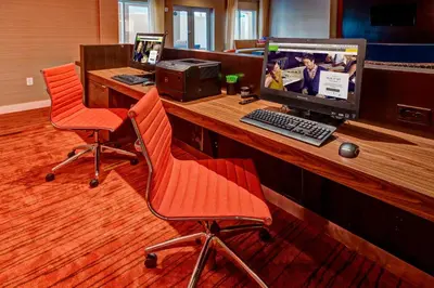 an office with two chairs and a computer on a desk at Courtyard by Marriott Westbury Long Island in Westbury