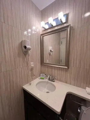 a bathroom with a sink and a mirror at Grandview Hotel New York in Queens