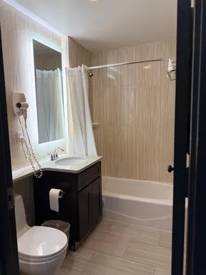 a bathroom with a sink and a toilet and a tub at Grandview Hotel New York in Queens