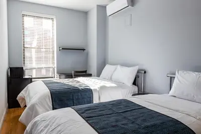 two beds in a room with a window at The Park Ave North in New York