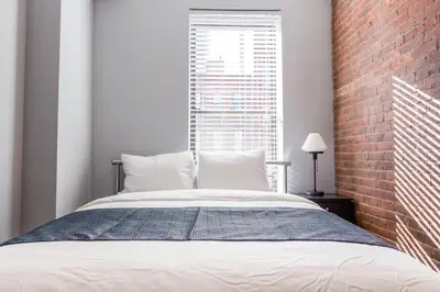 a bedroom with a bed with a brick wall at The Park Ave North in New York
