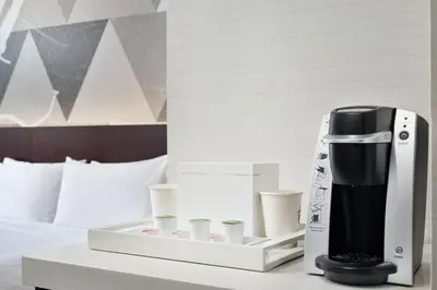 a coffee maker on a table next to a bed at Courtyard by Marriott Long Island City/New York Manhattan View in Queens