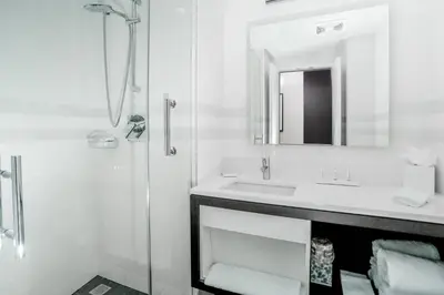 a white bathroom with a sink and a shower at Courtyard by Marriott Long Island City/New York Manhattan View in Queens