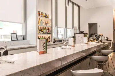 a bar with chairs and a counter with wine glasses at Courtyard by Marriott Long Island City/New York Manhattan View in Queens