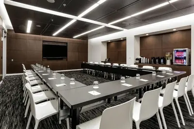 a large conference room with a long table and white chairs at Courtyard by Marriott Long Island City/New York Manhattan View in Queens