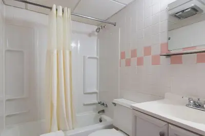 a bathroom with a shower curtain and a toilet and a sink at Knights Inn Amsterdam in Amsterdam