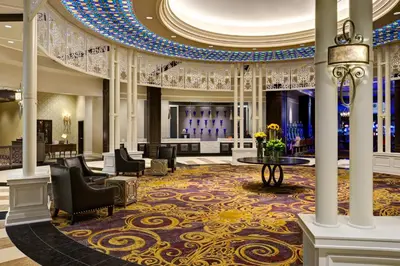 a lobby with chairs and a table in a building at Saratoga Casino Hotel in Saratoga Springs