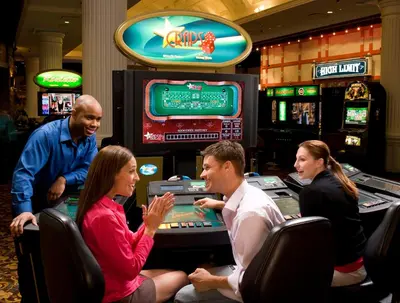 a group of people sitting at a slot machine in a casino at Saratoga Casino Hotel in Saratoga Springs