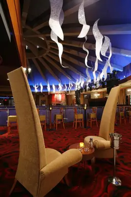 a restaurant with chairs and a bar with lights at Saratoga Casino Hotel in Saratoga Springs