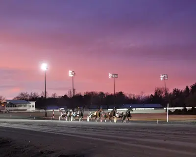 a group of horses racing on a race track at Saratoga Casino Hotel in Saratoga Springs