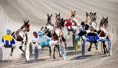 a group of horses racing around a race track at Saratoga Casino Hotel in Saratoga Springs